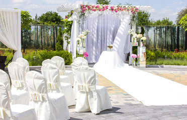 decoration of a wedding ceremony in nature, outdoor wedding decor, altar, white tone