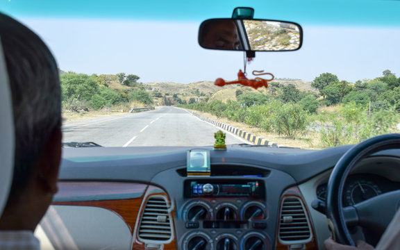 Car point of view image. Driving fast on a countryside asphalt road on a holiday. Jharkhand India