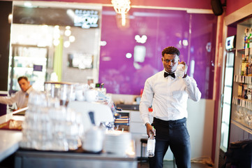 African american bartender at bar flair in action, working behind the cocktail bar. Alcoholic beverage preparation.