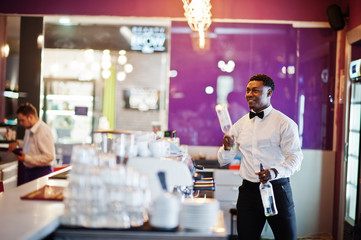 African american bartender at bar flair in action, working behind the cocktail bar. Alcoholic beverage preparation.
