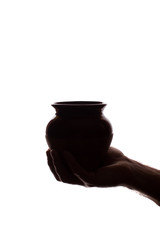 Hand young man holds ceramic pot - silhouette, concept