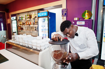 African american bartender barista at bar preparing coffee.