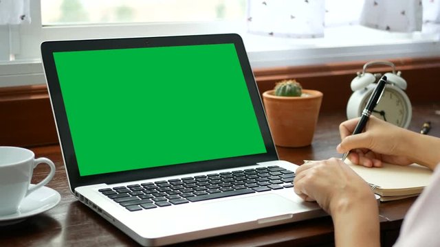4K. close-up woman learning online courses at home with notebook laptop, e-learning education concept . computer laptop with blank green screen chroma key.