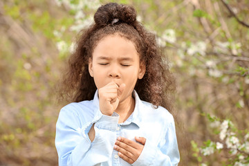 African-American girl having asthma attack outdoors on spring day