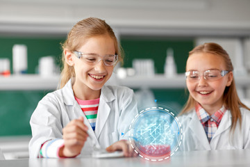 education, science, chemistry and children concept - kids or students making chemical experiment at...