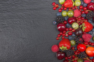 Various summer Fresh berries in a bowl on rustic wooden table. Antioxidants, detox diet, organic fruits. Top view