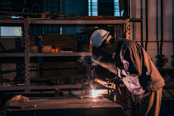 Welding metal at heavy industry factory.