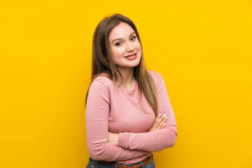 Obraz premium Teenager girl over isolated yellow background laughing