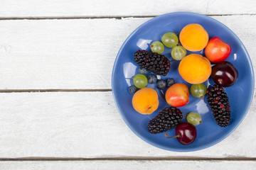 Various summer Fresh berries in a bowl on rustic wooden table. .Antioxidants, detox diet, organic fruits. Top view. Berries