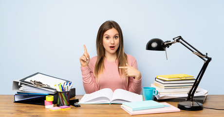 Teenager student girl in her room with surprise facial expression