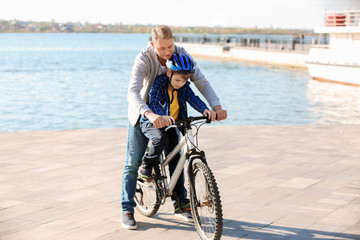 Father teaching his son to ride bicycle outdoors