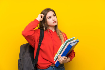 Teenager student girl over yellow background having doubts and with confuse face expression