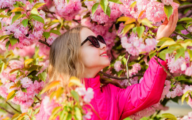Obraz na płótnie Canvas summer holiday. Childhood beauty. skincare. Natural cosmetics for skin. blossom smell, allergy. small girl in spring flower bloom. happy girl in cherry flower. Sakura tree blooming. Summer happiness