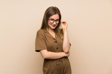 Teenager girl over isolated background with glasses and smiling