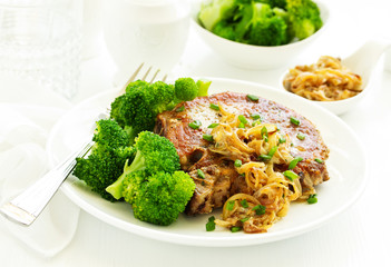 Fried pork steak with broccoli and onion sauce.
