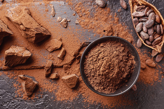Composition with cocoa powder, beans and chocolate on table