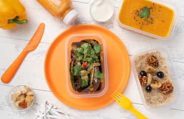 four course dinner. lentil vegetable cream soup, wild mushroom salad with celery, four cereals porridge with soy milk with nuts and blueberries and a bottle of pumpkin smoothie. still life of orange