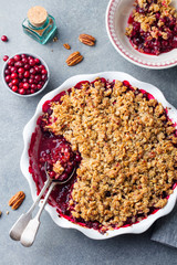 Cranberry crumble, crisp in a baking dish. Grey background. Top view.