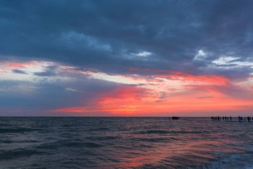 Sunset, moving clouds and sea waves on the beach . long exposure