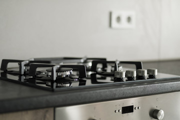 Modern kitchen, close up, gas stove with cooking pan, white and gray minimalistic interior design.