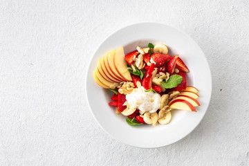 Fruit salad bowl on a white background top view. Healthy summer food