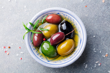 Olives assortment in bowl with oil. Top view. Close up.