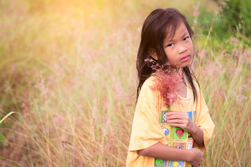 Rural children with grass flower.  Asian cute little girl at thailand