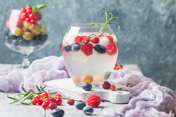 Detox fruit infused flavored water with ice. Refreshing summer homemade cocktail with berries