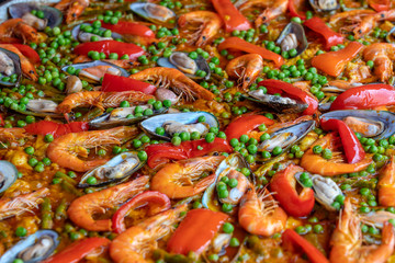 Spanish seafood paella in fry pan with mussels, shrimps and vegetables. Seafood paella background, closeup, traditional spanish rice dish