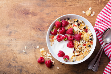 Healthy breakfast. Fresh granola, muesli with yogurt and berries on wooden background. Copy space....