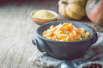 Millet porridge with sweet pumpkin in a bowl, rustic style. Healthy vegan dish.