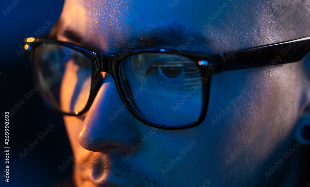 Poster vision, hacking and technology concept - close up of hacker eyes in glasses looking at computer scre