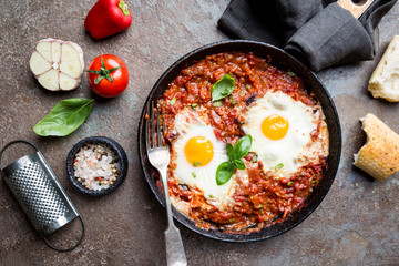 Shakshuka, Fried Eggs in Tomato Sauce in iron frying pan. Typical Israel food. Top view.