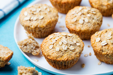 Healthy vegan oat muffins, apple and banana cakes on a white plate. Blue background.