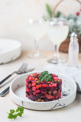 Russian beetroot salad vinaigrette in a white plate over light background