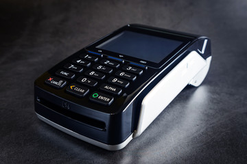 Obraz premium Pos terminal on a dark background. Banking equipment. Acquiring. Acceptance of bank credit cards. Contactless payment.
