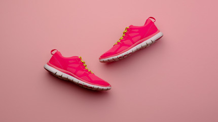 A studio shot of pair of running shoes on pink background. Flat lay.
