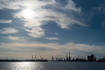 Naklejka premium Shipping port silhouette at sunset
