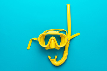 flat lay shot of yellow diving mask with snorkel over turquoise blue background. minimalist photo of dive mask and snorkel with central composition - obrazy, fototapety, plakaty