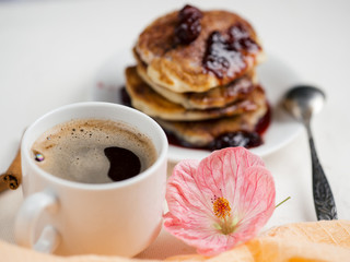 White coffee Cup and pancakes with cherry jam