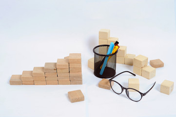 Wood block stacking as step stair on wooden table. Business concept for growth success process with color marker case and glasses