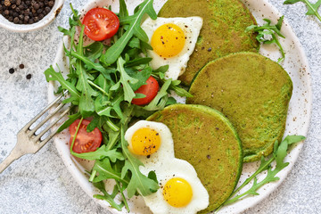 Morning breakfast: pancakes with spinach, salad and egg on the kitchen table. View from above.