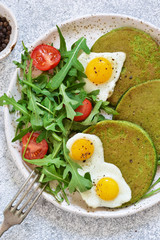 Morning breakfast: pancakes with spinach, salad and egg on the kitchen table. View from above.