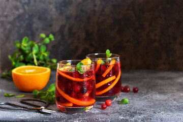 Cold cranberry juice with orange and mint. Summer drink.