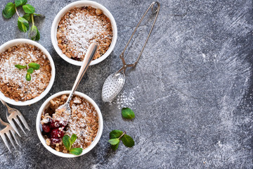 Cherry crumble with nuts and mint on a concrete background.
