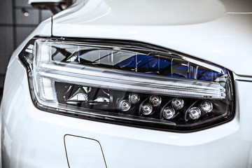 Macro view of modern car headlight SUV with noise graine effect. car xenon lamp headlight. detail...