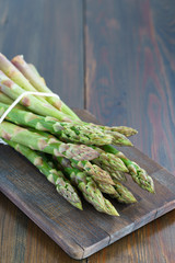 1 lb/0.5 kg of fresh organic asparagus on a wooden table. High resolution, negative space