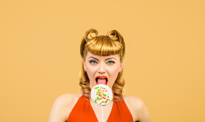 Lollipop. Sweet food. Sweets. Dessert. Sexy woman licks lollipop. Pin up model with lollipop in hand. Sexy girl with colourful candy. Candy store. Candy shop. Candy bar.