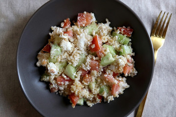 Bulgur wheat, tomato, cucumber and feta cheese salad. Top view.