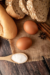 Fototapeta na wymiar Flour in wooden spoon and eggs on the sack
